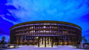 A modern building with a circular design, featuring a central open area and multiple floors.