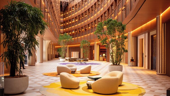 A spacious lobby with a checkered floor, seating areas, and potted plants. - THE PASONA natureverse retreat (Awaji)
