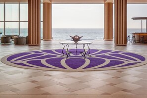 A spacious room with a large view of the ocean, a round table with a decorative centerpiece, and a purple patterned rug. - THE PASONA natureverse retreat (Awaji)