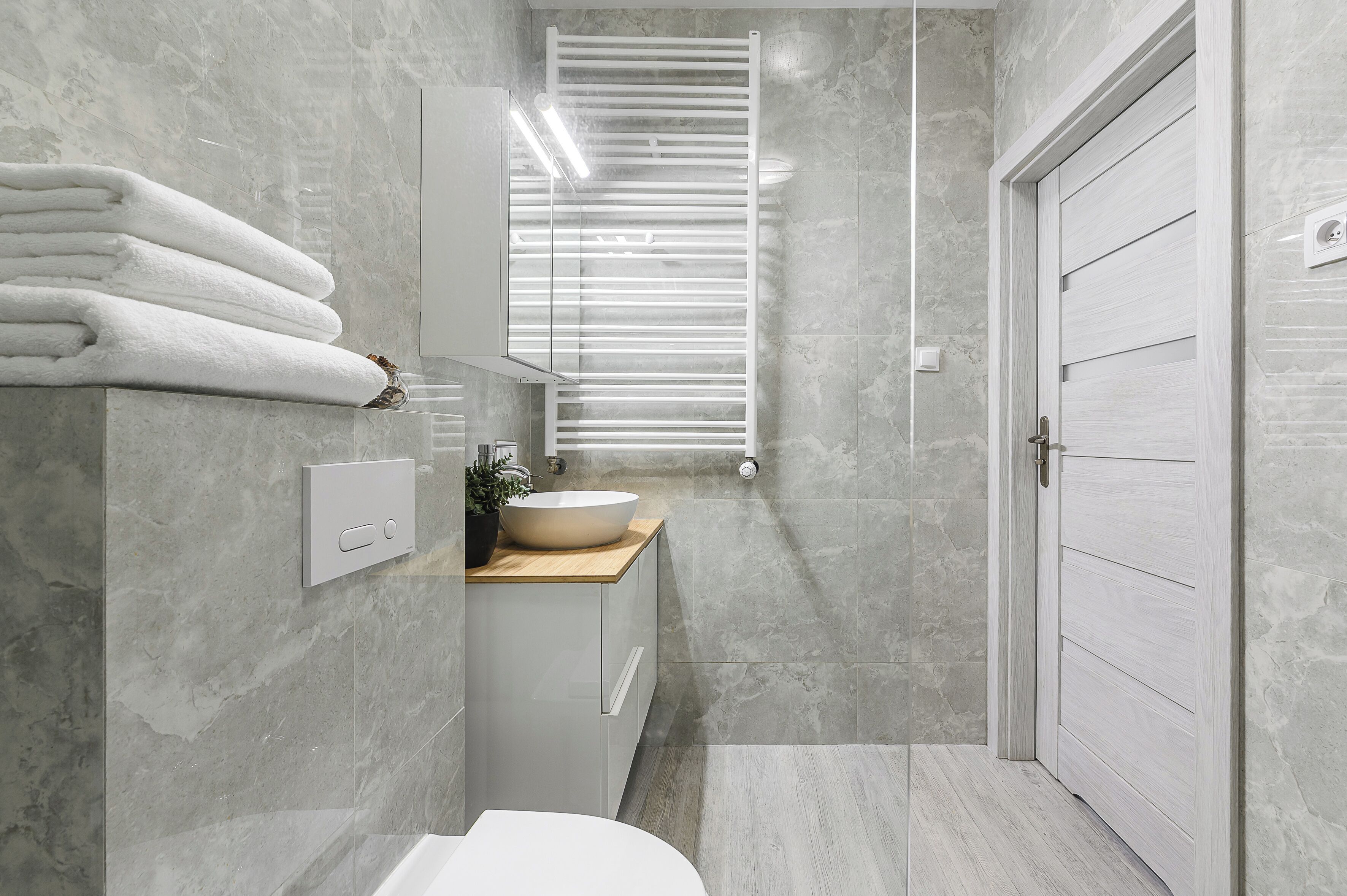 Une salle de bain moderne dotée d’un lavabo intégré, d’un porte-serviettes et d’un miroir.