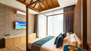 A modern hotel room with a large bed, a TV mounted on the wall, and a ceiling fan. - Luxury Teak 4BR Private Pool Villa in Bang Tao (Choeng Thale)