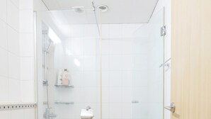 Une salle de bain moderne équipée de toilettes, d’un lavabo et d’un espace douche.