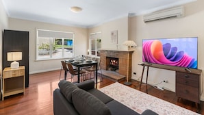 Una sala de estar con chimenea, comedor, televisor y sofá.