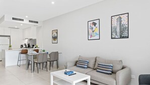 Una sala de estar moderna con sofá, mesa de centro y comedor.