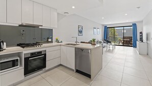 Una cocina moderna con una isla central, electrodomésticos integrados y un comedor con vistas.