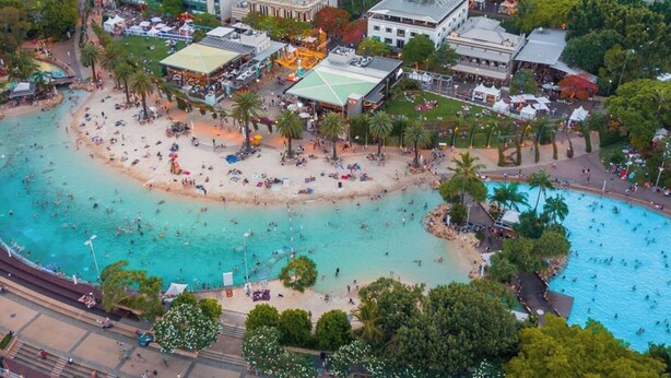Ein Luftbild eines Strandresorts mit mehreren Pools, einem Sandstrand und umliegenden Gebäuden.