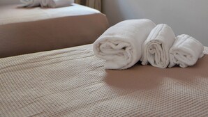 A hotel room with two beds, a window with curtains, and a radiator. - TRULLO MAMELI - DIEMME STAY (Alberobello)