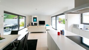 Une cuisine moderne avec un plan de travail blanc, un four à micro-ondes et un coin repas comprenant une table et des chaises.