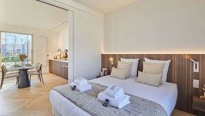 Een moderne hotelkamer met een groot bed, een zithoek en uitzicht op de stad.