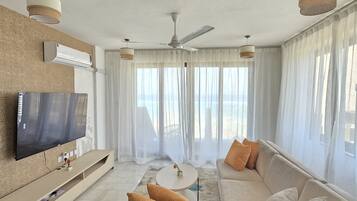 Apartamento, varias camas | Zona de estar | Smart TV de 55 pulgadas con canales digitales