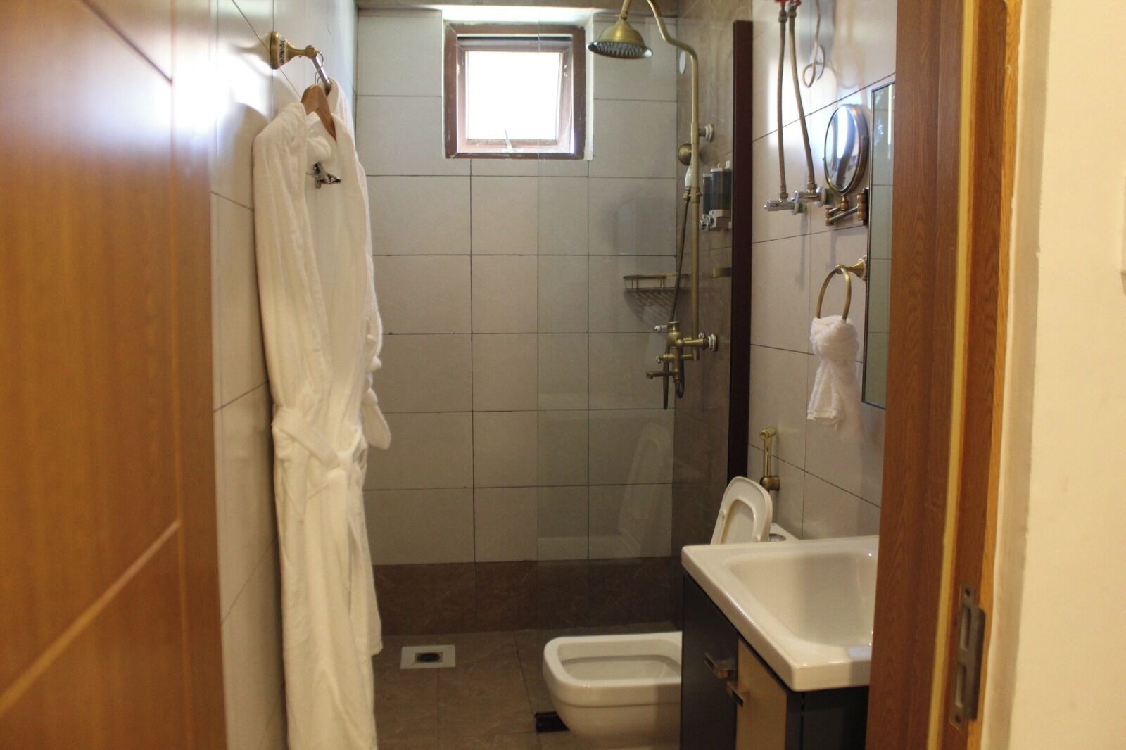 Een badkamer met een douche, toilet en wastafel.