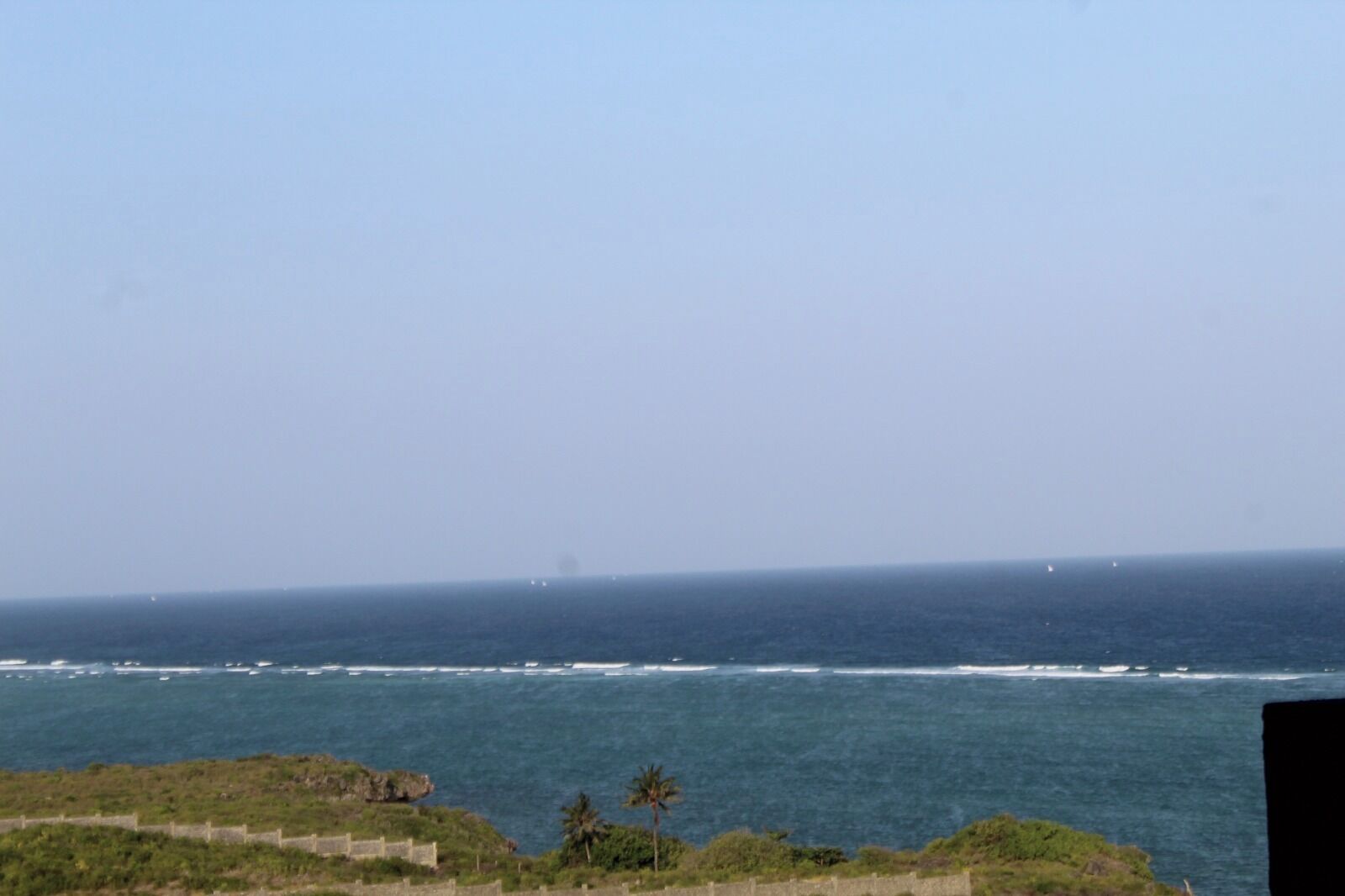 A coastal view with the ocean and a distant shoreline.
