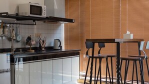 A modern kitchen with a microwave, stove, and bar stools.