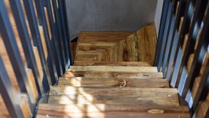 A wooden staircase with a modern design, featuring a central wooden handrail and steps made from various wood types.