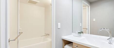 A bathroom with a shower, sink, and mirror.