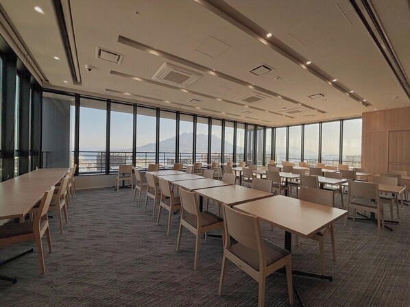 A conference room with large tables and chairs, a carpeted floor, and a view of the mountains through large windows. - HOTEL GRAN CEREZO KAGOSHIMA TENMONKAN (Kagoshima)