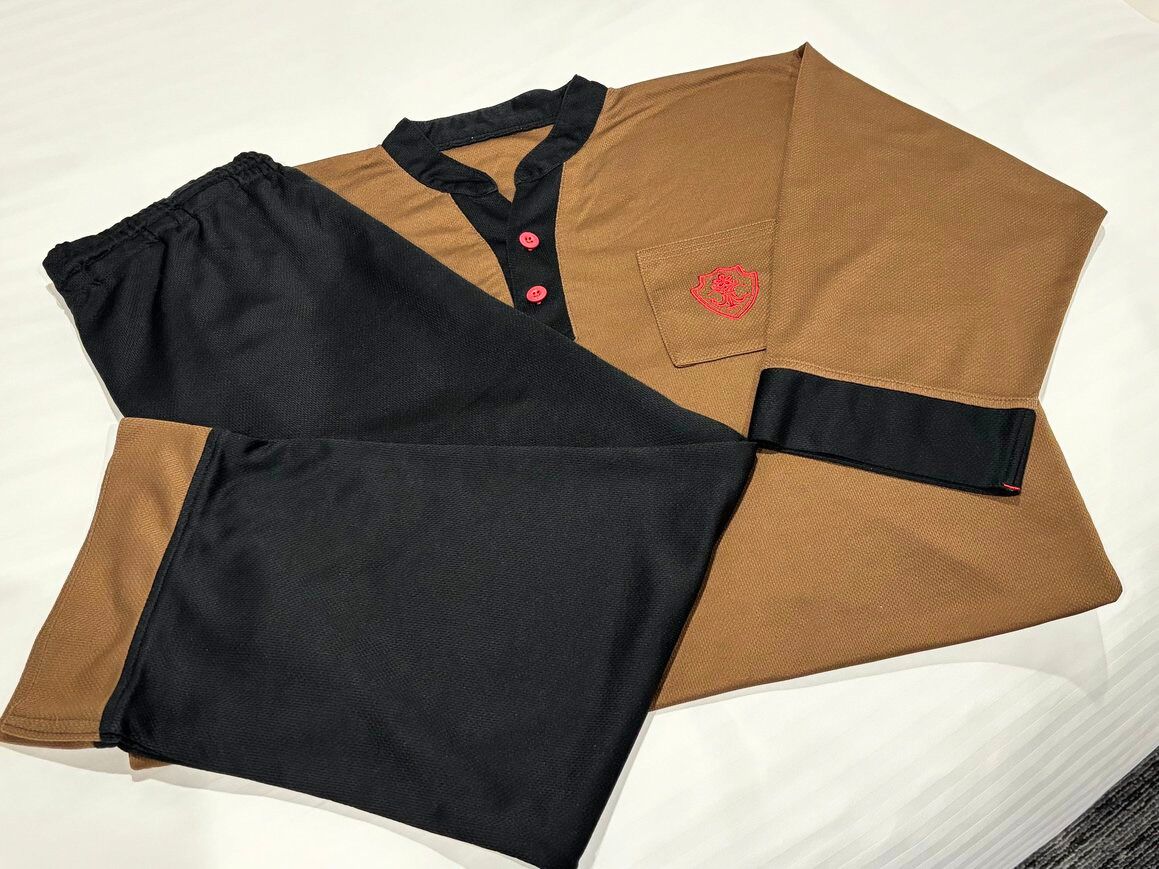 A black and brown shirt with a red logo on the pocket.