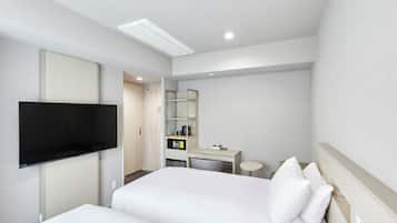 A hotel room with a bed, a desk, a chair, a television, and a wardrobe.