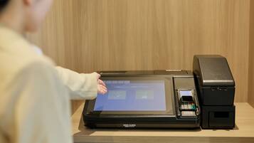 A person interacting with a digital kiosk, likely for check-in or information.