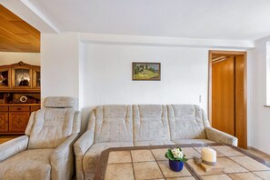 Ein Wohnzimmer mit einer Couch, einem Couchtisch, einem Schrank und einer Tür.