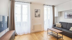 Ein modernes Wohnzimmer mit einer Couch, einem Couchtisch und einem Fernseher.