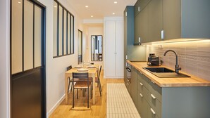 Eine moderne Küche mit einer Holz Arbeitsplatte, einer integrierten Spüle und einem Essbereich mit Tisch und Stühlen.