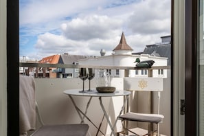 A balcony with a table, two wine glasses, a bowl, and a duck statue. - Utkiek - Modern apartment, close to the beach, balcony, parking space, WLAN. Pets allowed. (Sylt)