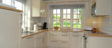 Kjøleskap, ovn, kokeplater og spisebord