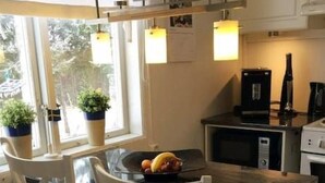Une cuisine compacte comprenant une table et des chaises, un four à micro-ondes et une machine à café.
