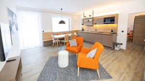 A modern apartment with a dining area, kitchen, and living room.