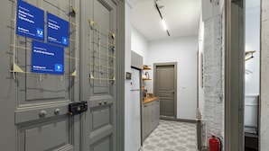 Un couloir avec un sol à motifs, un extincteur et une porte sur laquelle sont exposées des récompenses.