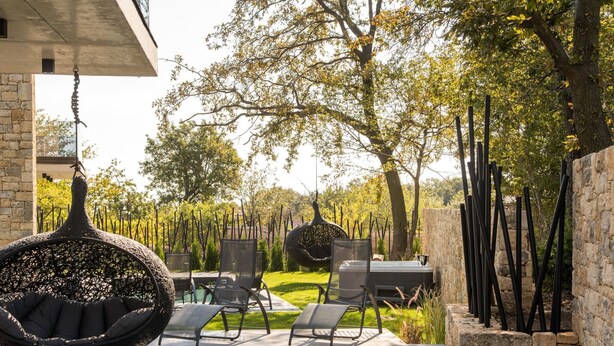 A pool area with lounge chairs, a hot tub, and a hanging chair. - Nettes Ferienhaus mit Privatem Pool by Interhome (Varna)