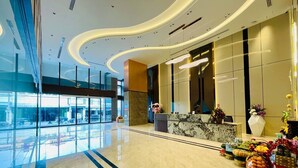 A modern hotel lobby with a marble reception desk, large windows, and a view of the city. - LN Hotel & Residence  (Phnom Penh)