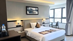 A modern hotel room with a large bed, bedside tables, a desk, and a chair. - LN Hotel & Residence  (Phnom Penh)