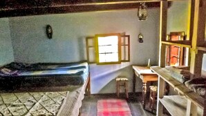 Quarto com uma cama, uma mesa e uma janela.