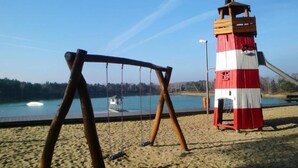 Een strand met een schommel en een rode en witte wachttoren.