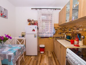 Eine kleine Küche mit Holzschränken, einem Kühlschrank, einer Spüle und einem Herd.