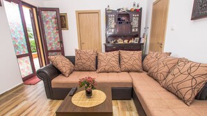 A living room with a sofa, a coffee table, and a cabinet. - Familienfreundliche Wohnung direkt am Meer by Interhome (Dobrota)