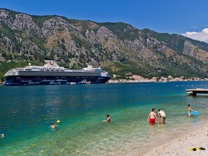 A cruise ship docked at a harbor with clear blue water and rocky hills in the background. - Ruhiger Ort im Herzen einer Bucht by Interhome (Dobrota)