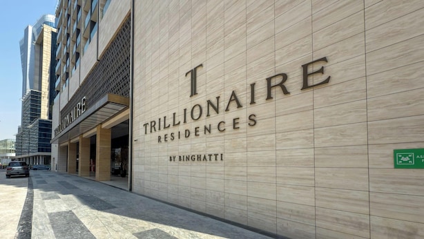 Een gevel van een gebouw met de naam "TRILLIONAIRE RESIDENCES" en "BINGHATTI", wat een luxe wooneigendom aangeeft.