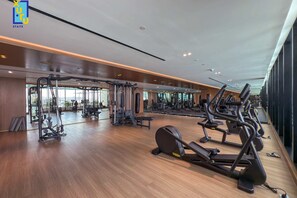 A spacious gym with various exercise equipment, large windows, and a modern design. - Timeless & Textured Studio w/ Jacuzzi Trillionaire (Dubai)