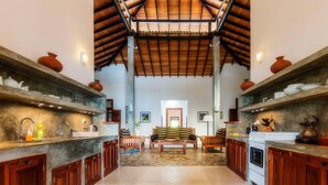 Una cocina amplia con armarios de madera, una zona de estar central y suelo de baldosas.
