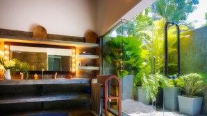 Un baño moderno con un espejo grande, estantes empotrados y una cabina de ducha de vidrio.