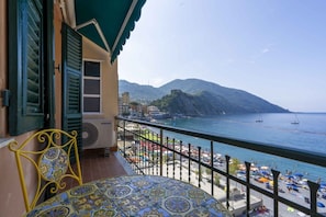 A balcony with a view of the sea, a chair, and a table with a patterned tablecloth. - SUMMER HOUSE CAMOGLI - Relax at sunset on the Ligurian coast  (Camogli)