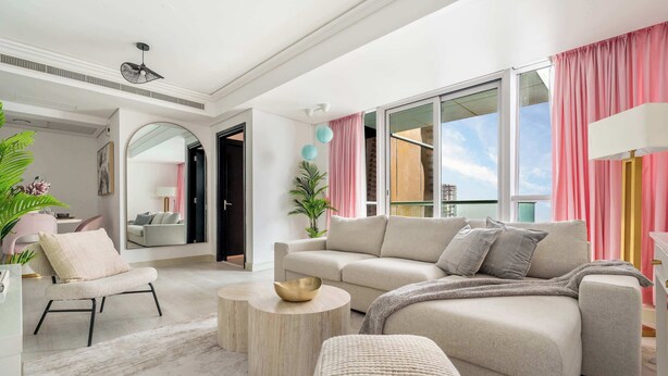 Una sala de estar moderna con un sofá, un sillón y una mesa de centro redonda.