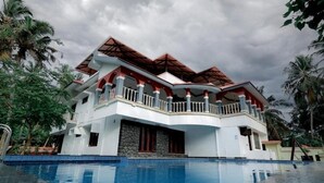 A large, multi-story building with a swimming pool in front.