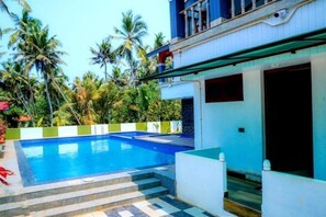 Ein Pool mit Stufen, umgeben von einem weißen Gebäude mit einem Balkon.