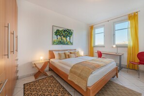 Une chambre à coucher moderne avec un grand lit, un bureau et une chaise.