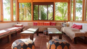 A cozy room with a sofa, two small tables, and two ottomans. - Oasis Al Hamam Wellnesscamp  (Lucainena de las Torres)