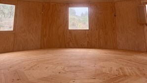 A circular room with a wooden floor and walls, featuring a skylight and two windows. - Oasis Al Hamam Wellnesscamp  (Lucainena de las Torres)